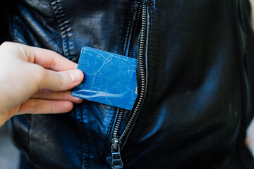 From the pocket of jacket the thief pulls out a card banknote money purse wallet.