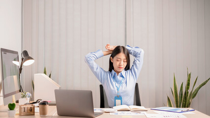 Businesswomen beautiful young asia is stretching her arms and feeling relax after hard work.