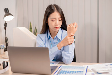 Businesswoman asia is sitting at workplace and feeling muscle aches from hard work. © nBhutinat