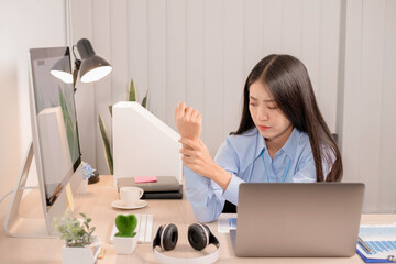 Businesswoman asia is sitting at workplace and feeling muscle aches from hard work. © nBhutinat