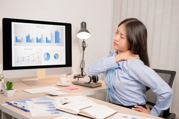 Businesswoman asia is sitting at workplace and feeling muscle aches from hard work.