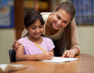 School, study or learning with a student and teacher in a classroom together for writing or child development. Education, scholarship and teaching with a woman tutor helping a girl child in class