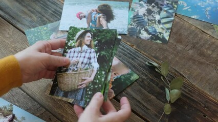 Woman looking through pictures printed on photo paper.