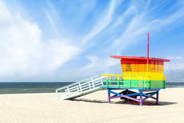 A vibrant photo of a lifeguard tower in the colors of the pride flag