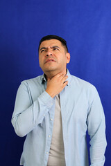 Obraz premium Dark-haired Latino adult man is sick, has a sore throat and suffers from strep cough and tonsil infections