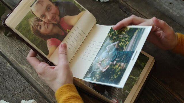 Photo printing concept. Woman flips through photo album looks at photos in it.