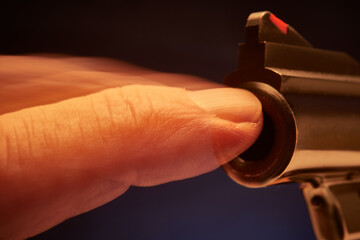Finger blocking the barrel and the firing of a pistol