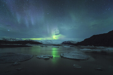 Scenic view of aurora borealis over icebergs in Iceland