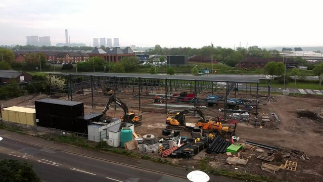 Aerial view of Aldi grocery store building site foundation steel framework and construction equipment under power station skyline