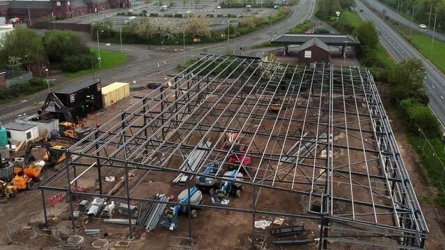 Aerial rising view of Aldi supermarket site foundation steel framework and construction equipment