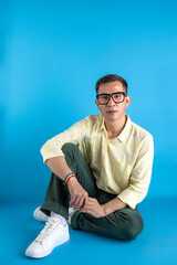 Man with eyeglasses and a shirt wearing a rainbow bracelet