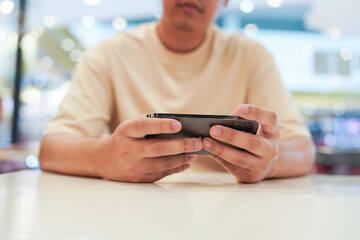 Man playing game on mobile phone. gamer boy playing video games holding Smartphone working mobile devices. cell telephone technology e-commerce concept