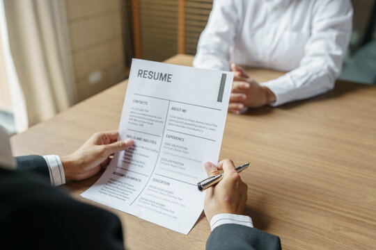 Examiner reading a resume during job interview at office Business and human resources concept