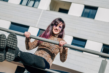 funny young woman posing on the railing on the street