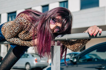funny young woman posing on the railing on the street