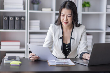 Financial Business asian women analyze the graph of the company's performance to create profits and growth, Market research reports and income statistics, Financial and Accounting concept.	