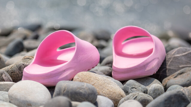 Pink flip flops on stone pebbles