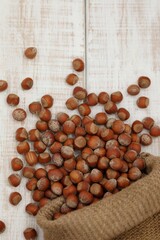 Scattered hazelnuts on a white table, raw, in shell, stock, healthy food, background image, background, story, wallpaper, for typing, for presentation,nut, nuts, nutritious, vitamins, vitamin, consump