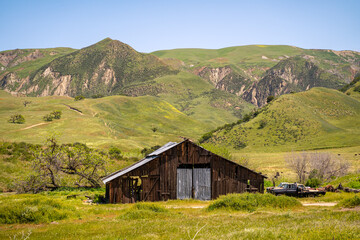 Fototapeta na wymiar Old barn next to beautiful mountains.