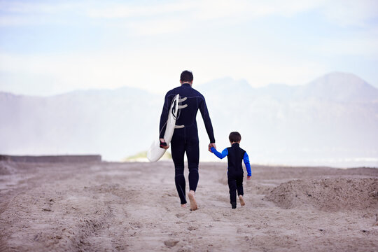 Beach, father and son with surfing lesson, walking and bonding on summer vacation, loving and quality time. Family, parent and dad with boy, male child and kid with surfboard and seaside holiday - Powered by Adobe