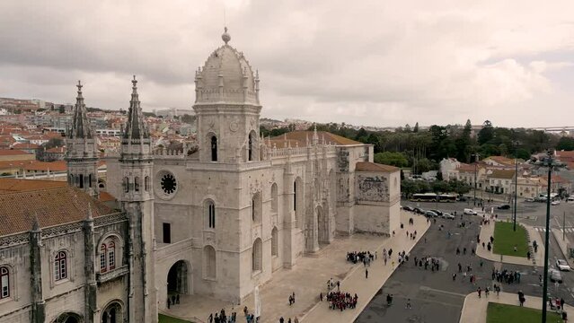 Astounding Gothic Style Of Jeronimos Monastery With Tourists Outside The Building On A Cloudy Day In Belem, Lisbon, Portugal. aerial