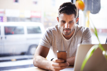 Phone, laptop or man in cafe reading news on social media for an update on the stock market for trading. Coffee shop, entrepreneur or trader texting on mobile app or networking on internet or website