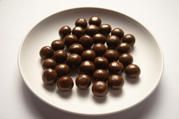 chocolate balls on a white plate on a white background