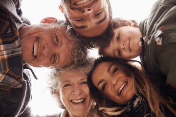 Faces, smile and below portrait of happy family together on outdoor vacation or holiday feeling excited. Grandparents, happiness and parents in a circle with child or kid for love and care