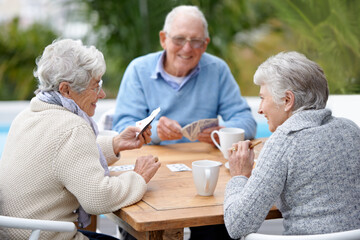 Poker, smile and senior group with retirement, outdoor and cheerful together with joy, relax and...
