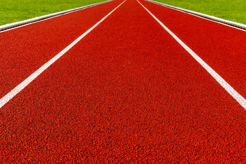 Red running track with a green grass on both sides