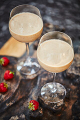 Its not Valentines Day without a little treat. a freshly made cream snack served in a glass with strawberries on a table.