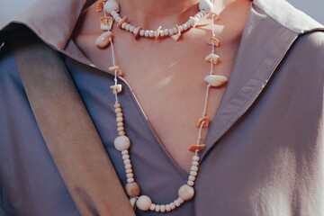 Grey shirt cotton material and bohemian wooden beads accessories. Female fashion fancy details