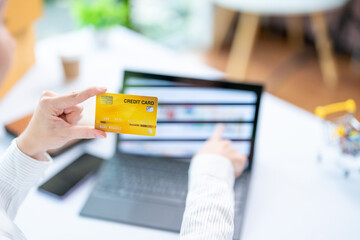Concept of Online shopping, e-commerce, Woman holding credit card and using laptop computer for shopping online,Businesswoman paying for goods or services using credit card through online channels