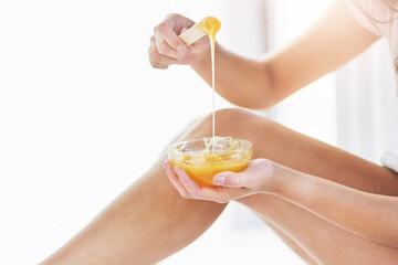 Theyll be smooth to the touch soon. Closeup shot of an unrecognizable woman waxing her legs in the bathroom at home.