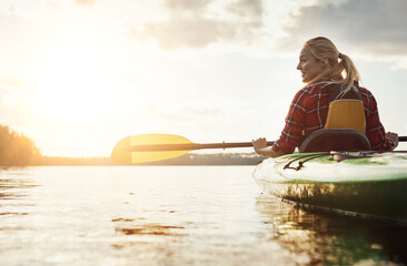 Find your inner peace. a young woman kayaking on a lake.