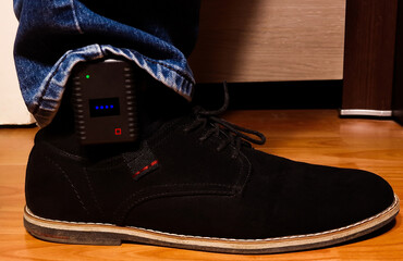 A close-up of a GPS tracking device on a man's leg, used by the police to monitor violent people
