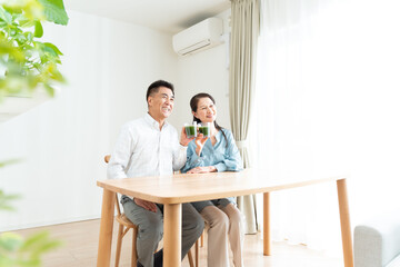 Obraz premium リビングで青汁を持つシニア夫婦