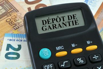 Concept de dépôt de garantie avec une calculatrice en gros plan sur fond de billets de banque en...