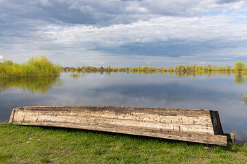 wooden boat on the background of the flood of the river in spring