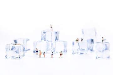 Miniature people in swimsuit playing on ice cube. Summer holiday. anti hot temp concept. isolate white background.