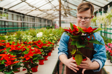 Young man with down syndrome working in greenhouse