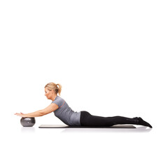 Pushing it down and holding it there. A young woman using an exercise ball while lying down - isolated.