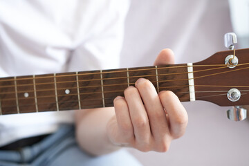 Young man playing guitar, closeup of hands. Music concept.