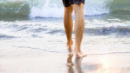 Feet walk on the beach in the sea