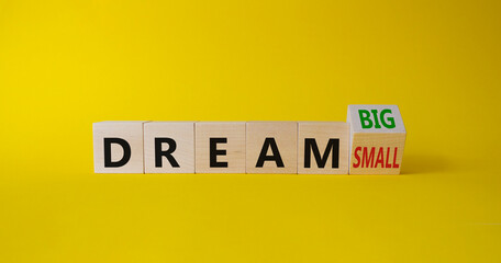 Dream Big vs Small symbol. Wooden cubes with words Dream Small and Dream Big. Beautiful yellow background. Business and Dream concept. Copy space