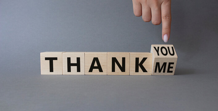 Thank You or Me symbol. Businessman Hand points at wooden cubes with words Thank Me and thank you. Beautiful grey background. Business and Thanks concept. Copy space