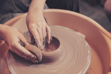 closeup woman hands working handcraft on pottery wheel making clay pot terracotta.