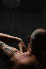 Tattooed man taking a shower