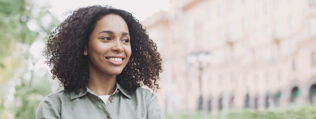 Young woman in a city looking away, African-american student girl portrait, Young businesswoman...