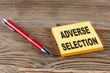 ADVERSE SELECTION text on sticky with pen on the wooden background